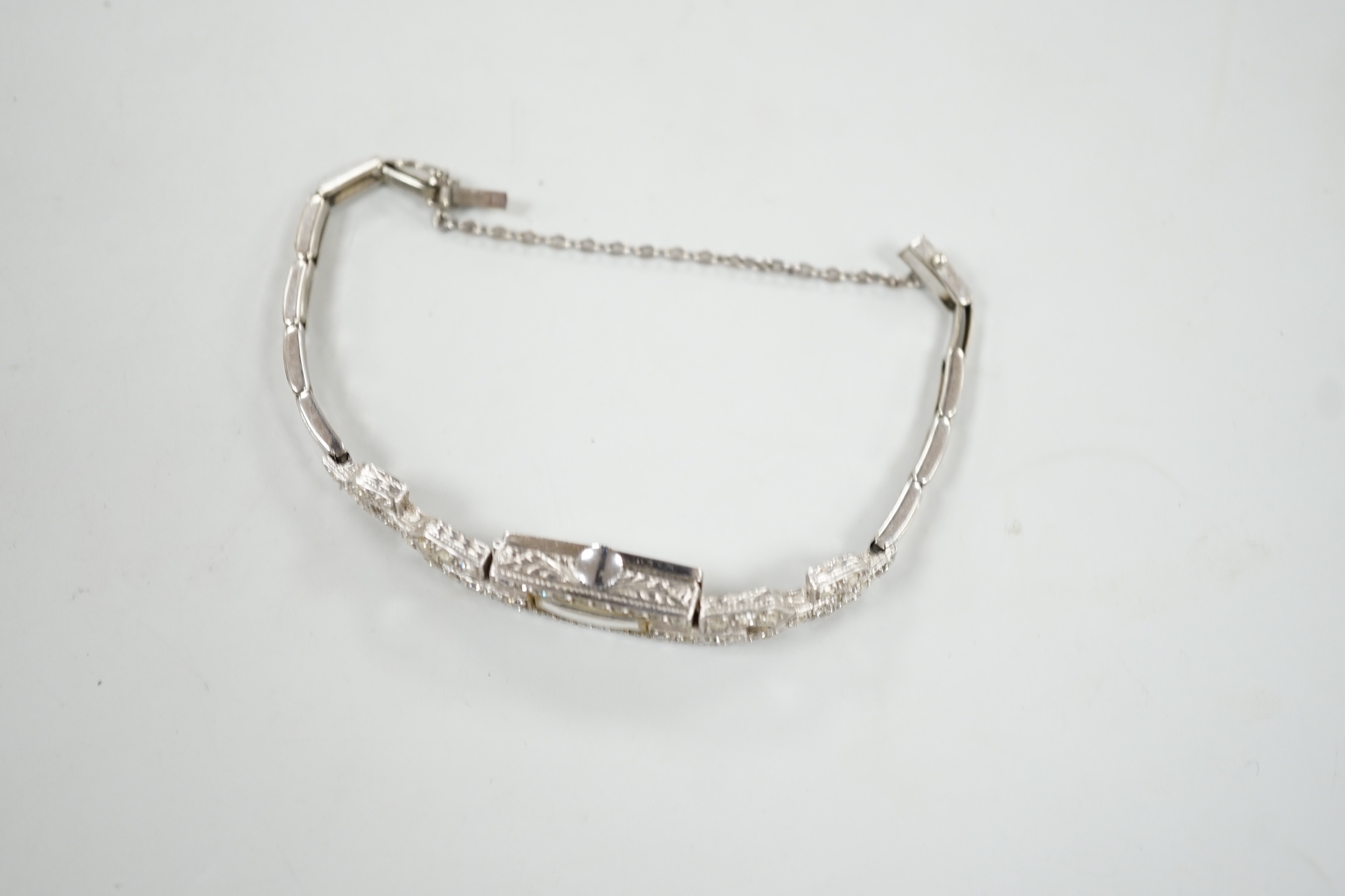 A lady's platine and diamond cluster set manual wind cocktail watch, with rectangular Arabic dial, on a white metal expanding bracelet, 16cm, gross weight 15 grams.